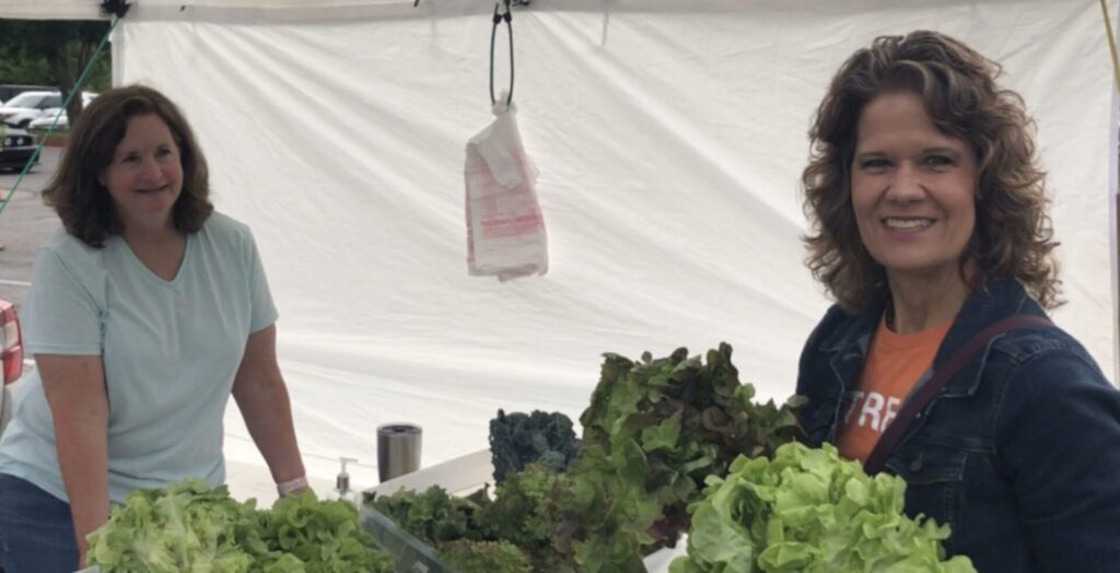 Photo of Krista buying beautiful greens from the farmers' market