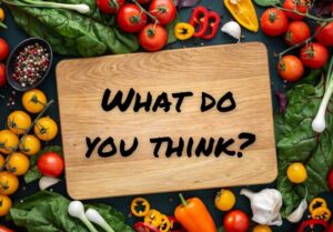 Cutting board surrounded by vegetables with the caption "What Do You Think?"